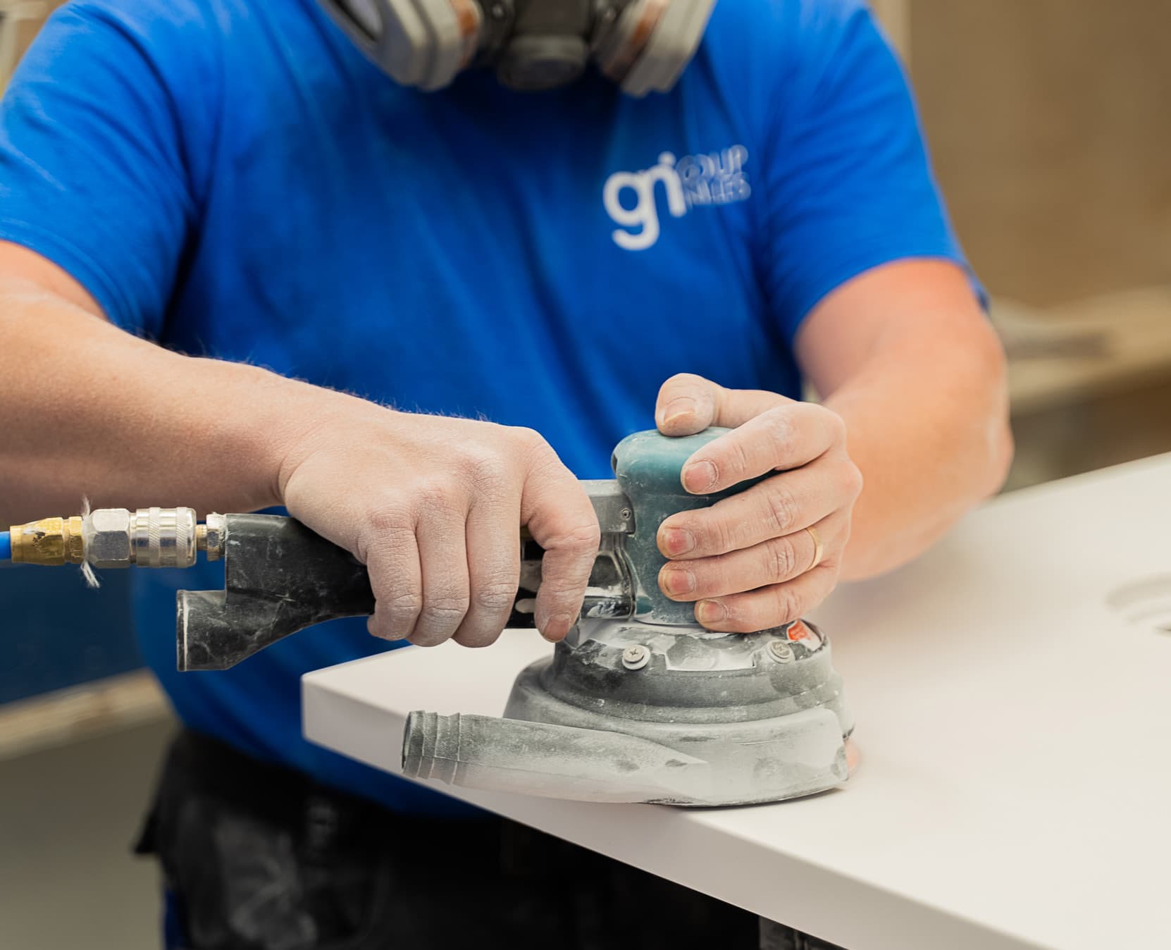 Vakman schuurt een solid surface blad in het Group Nivelles atelier